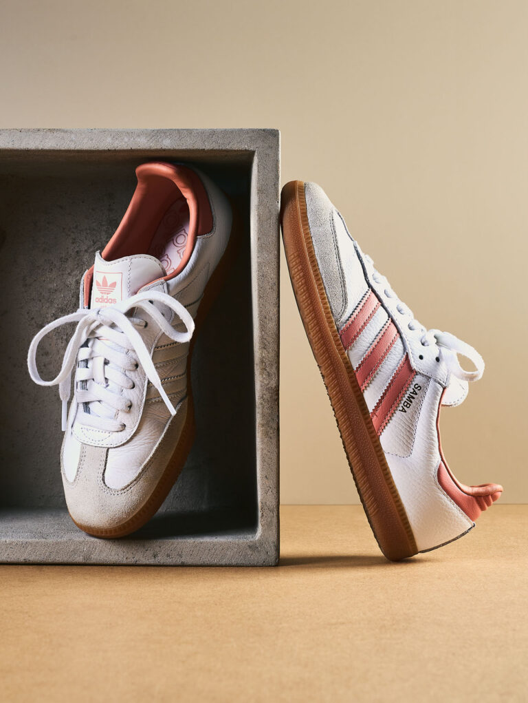 Contemporary lifestyle and product photography showcasing the iconic Samba sneaker design in a minimalist, urban fashion setting, showcasing a creative product composition with the sneakers arranged inside and next to a clean concrete display block.